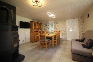 - une cuisine et une salle à manger avec une table et un canapé dans l'établissement Gîte à Rufus, Maison de charme au Ménil, au cœur de la nature vosgienne, à Le Ménil