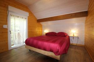 - une chambre avec un lit doté de draps rouges et une fenêtre dans l'établissement Gîte à Rufus, Maison de charme au Ménil, au cœur de la nature vosgienne, à Le Ménil