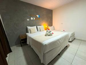 a bedroom with two beds with shoes on the bed at Casa Flôr in Fernando de Noronha