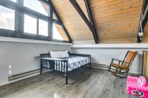 a room with a bed and a chair and windows at 5 Mi to Dtwn Evergreen Mtn-View Escape in Evergreen