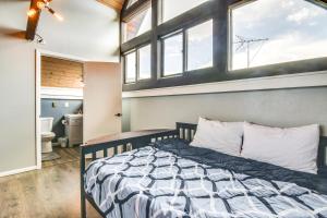 a bedroom with a bed in a room with windows at 5 Mi to Dtwn Evergreen Mtn-View Escape in Evergreen