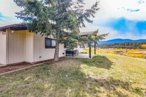 a house with a table and a tree in the yard at 5 Mi to Dtwn Evergreen Mtn-View Escape in Evergreen