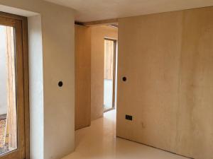 una stanza vuota con un muro e una finestra di The Old Milking Barn Loft a Tiverton