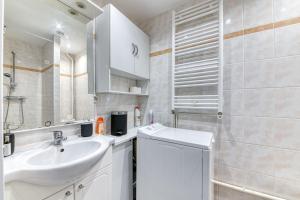 a white bathroom with a sink and a shower at Charming Flat in Villeurbanne Gratte-Ciel in Villeurbanne