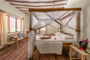 - une chambre avec un lit à baldaquin et des draps blancs dans l'établissement Hakuna Majiwe Beach Lodge, à Paje 148 autres photos