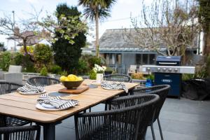 a wooden table with chairs and a bowl of fruit on it at Harbourside luxury house in Aberaeron