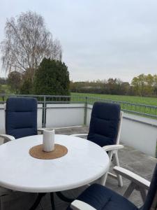 a white table and two chairs on a patio at Monteurwohnung nahe A1 in Ostbevern