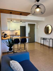 un soggiorno con un divano blu e una cucina di Casa Oti en Roque del Mar a Costa de Antigua