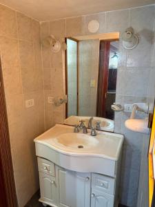 a bathroom with a white sink and a mirror at Casa feliza in Villa Dolores
