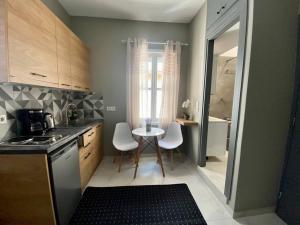 a kitchen with a table and white chairs in it at The Central Retreat 4 in Mytilene