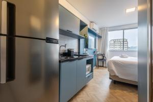 a kitchen with a refrigerator and a bed in a room at 360 Nações Unidas in Sao Paulo