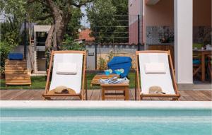 dwa krzesła i stół obok basenu w obiekcie Two-Bedroom Holiday Home In Barbariga w mieście Barbariga +19 zdjęć