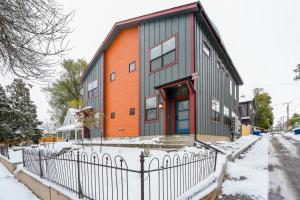 Ein orange-graues Gebäude mit einem Zaun im Schnee in der Unterkunft El Paso Executive Suites - Pet Friendly NEW BUILD in Colorado Springs