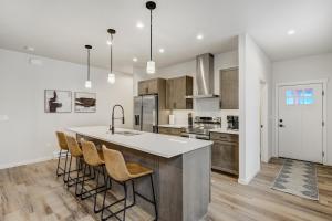 eine Küche mit einer großen Insel mit Barhockern in der Unterkunft El Paso Executive Suites - Pet Friendly NEW BUILD in Colorado Springs + 12 Fotos