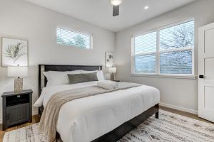 ein Schlafzimmer mit einem großen Bett und zwei Fenstern in der Unterkunft El Paso Executive Suites - Pet Friendly NEW BUILD in Colorado Springs