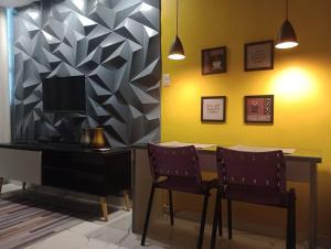 a table with two chairs and a desk with a television at Studio Pelourinho, Salvador in Salvador