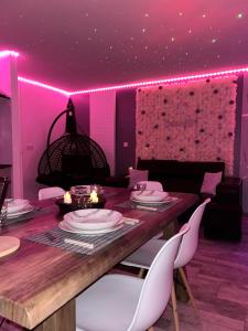 a dining room with a table and pink lighting at Diamond Spa in Sallaumines