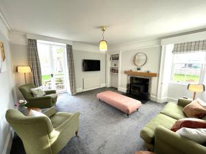a living room with two couches and a tv at Garden House - Brodie Castle in Forres