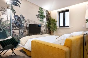 a bedroom with a large bed and a yellow chair at Savannah Apartment, by Bolhão Residences in Porto