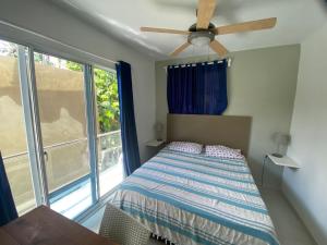 Un dormitorio con una cama y un ventilador de techo. en Big Blue Apartments, en Cabarete 42 fotos más