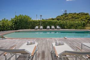 a swimming pool with two tables and chairs next to it at Le Spot - Unique house with view in Oyster Pond