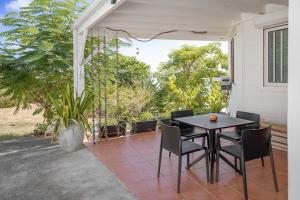 a patio with a table and chairs on a porch at Le Spot - Unique house with view in Oyster Pond