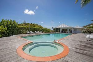 a swimming pool with chairs and a house at Le Spot - Unique house with view in Oyster Pond