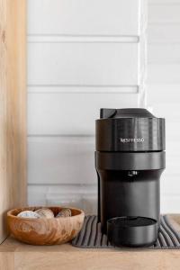a coffee maker on a counter with a bowl of money at Le Spot - Unique house with view in Oyster Pond