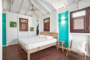 a bedroom with a bed and a chair in it at Le Spot - Unique house with view in Oyster Pond +37 photos