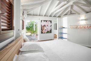 a bedroom with white walls and a large bed at Le Spot - Unique house with view in Oyster Pond