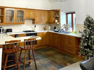 a kitchen with wooden cabinets and a christmas tree at Braunton Breaks - 'The Snug' in Braunton