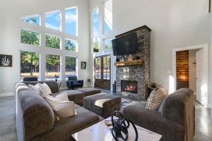 un salon avec des canapés et une cheminée dans l'établissement 3 Mi to Lake Cabin with Hot Tub in Broken Bow!, à Stephens Gap