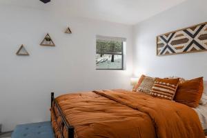 a bedroom with a bed with an orange blanket at Skyes Hideaway Walk to Lifts in Angel Fire