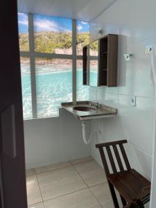 a bathroom with a sink and a view of the ocean at Pousada Recanto do Arraial do Cabo in Arraial do Cabo