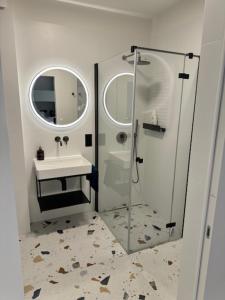 un bagno con doccia, lavandino e specchio di Apartament Baltic Zefir Pogorzelica Sea&Spa-Hevenia a Pogorzelica Altre 15 foto