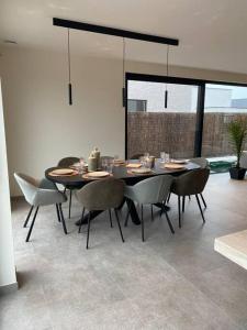 a dining room with a table and some chairs at Maison Impression vakantiehuis in Middelkerke