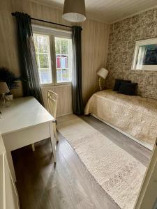 Un dormitorio con una cama y un escritorio y una ventana. en Villa Kesälä, en Ylöjärvi 12 fotos más