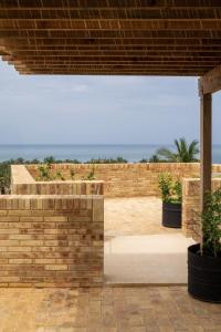- un mur en briques avec vue sur l'océan dans l'établissement Torrearena Design Hotel, à Puerto Escondido