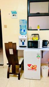 a kitchen with a table and a chair and a microwave at Rosette Haven 2 in Nairobi