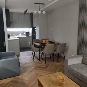 a living room with a table and chairs and a couch at Central Park Green Apartament in Wrocław