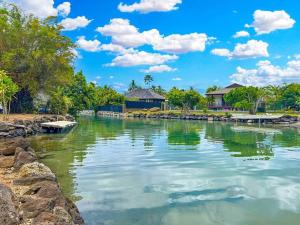 a river with houses in the background at Free canoës King Bed - Fare Vaihere in Moorea