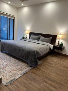 a bedroom with a large bed and a large window at Beverly Hills Residence Murree By Goldfinch in Islamabad
