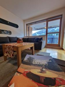 a living room with a couch and a table at BJELAŠNICA BEX APARTMANI in Bjelašnica +20 photos