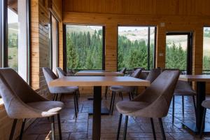 a row of tables and chairs in a room with windows at A Pisc in Vatra Moldoviţei