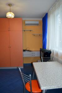 キーウにあるApartment Laboratorniy per. 26のテーブルと椅子、キッチンが備わる客室です。