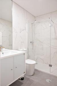 un bagno bianco con wc e doccia di Savannah Apartment, by Bolhão Residences a Porto