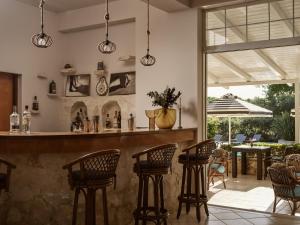 eine Bar mit Stühlen und einem Tisch mit einem Sonnenschirm in der Unterkunft AQUARIUS HOTEL in Vasilikos