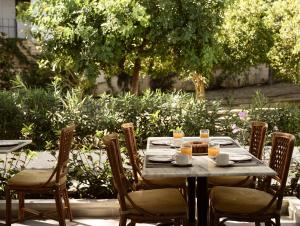 a wooden table with chairs and a table with food on it at AQUARIUS HOTEL in Vasilikos