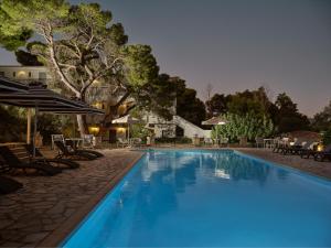 a large swimming pool with chairs and umbrellas at AQUARIUS HOTEL in Vasilikos