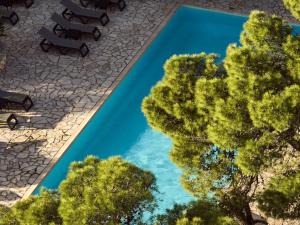 an overhead view of a pool with chairs and trees at AQUARIUS HOTEL in Vasilikos